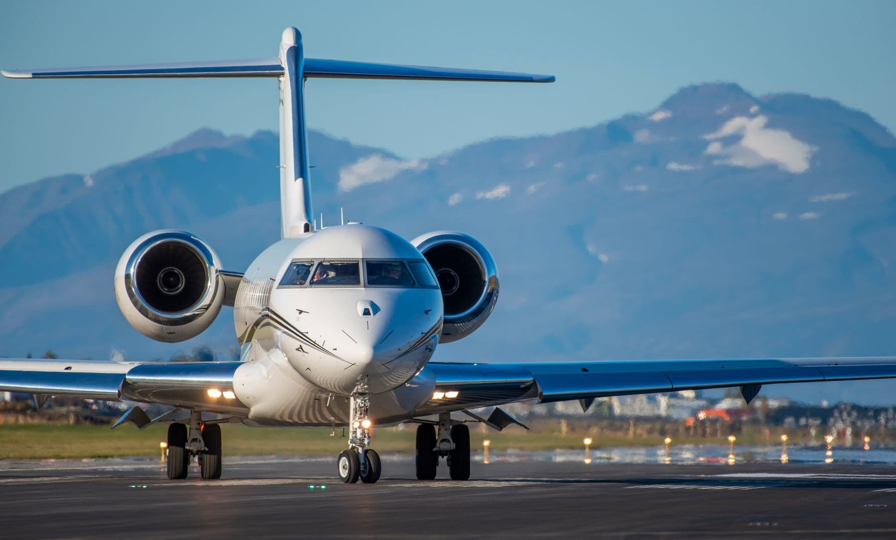 Private jet on a runway with mountains in the distance
