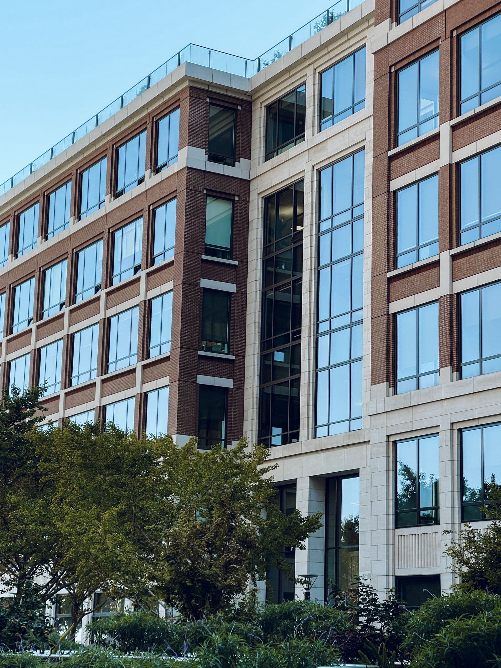 Contemporary brick and glass commercial building surrounded by trees