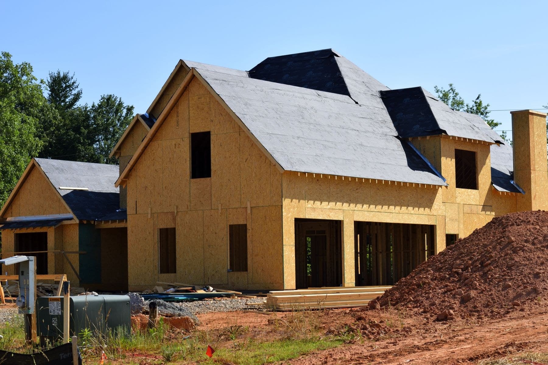 New house under construction with exposed timber sheathing and an unfinished garage
